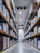 High-ceiling warehouse freezer with pallet racking and boxed inventory along a clear central aisle